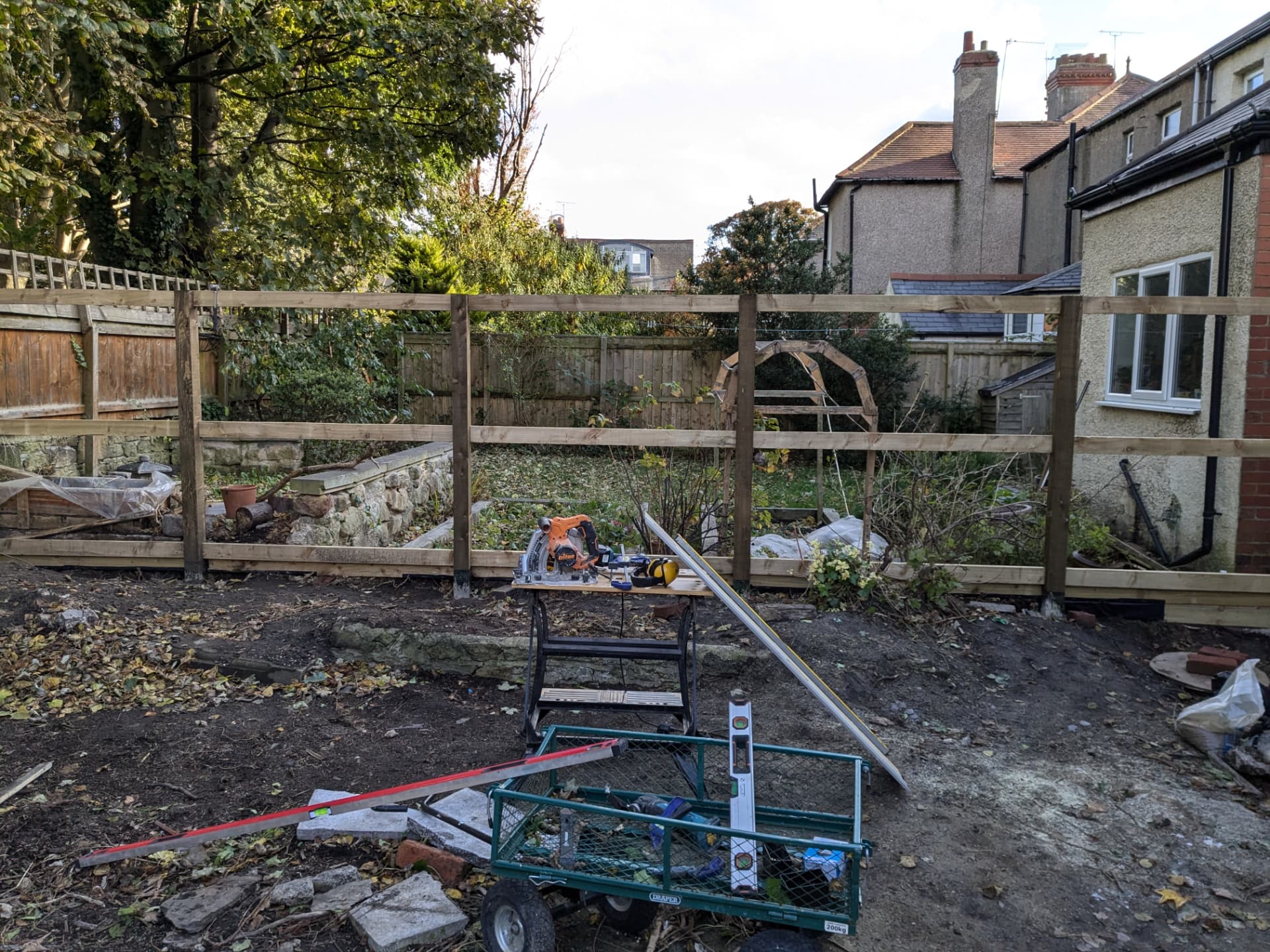 Fence build — posts and rails set out along the boundary