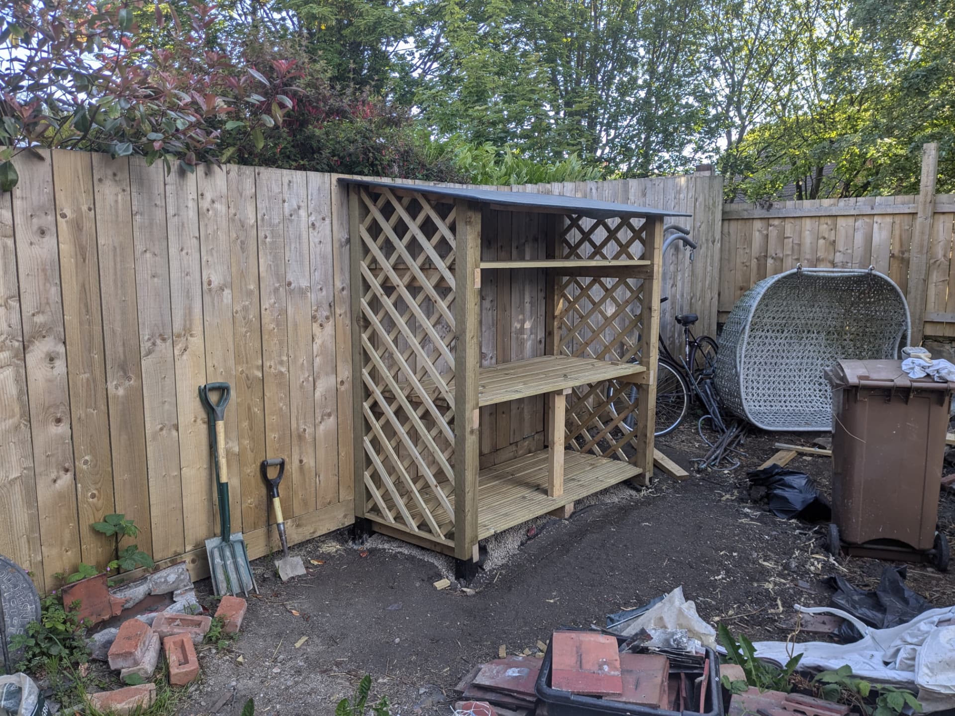 Custom woodshed — side angle showing lattice panels and roof