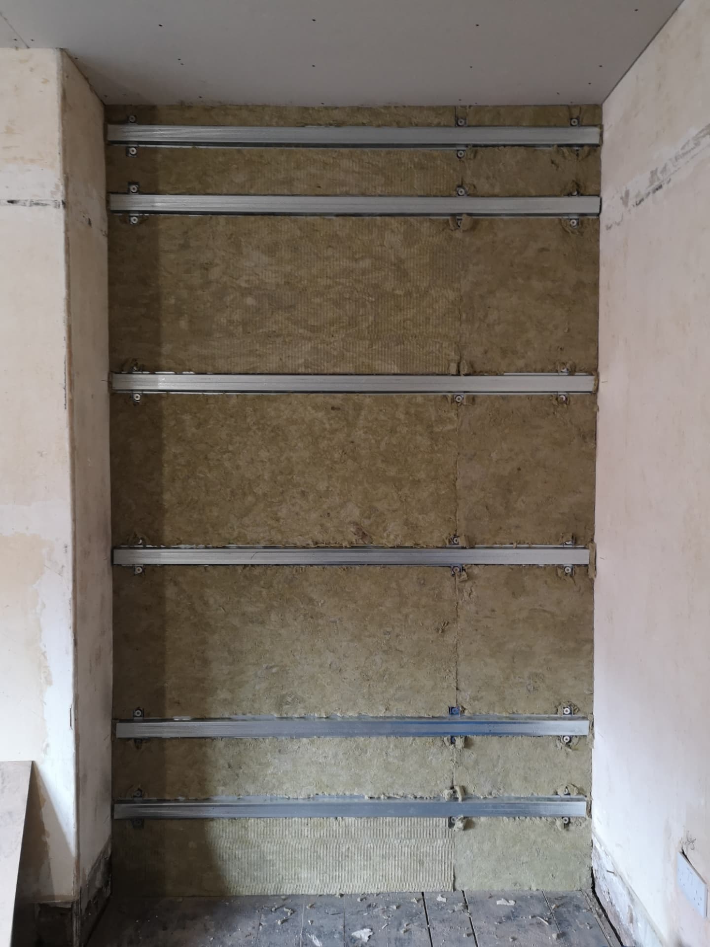 Alcove soundproofing — acoustic mineral wool packed between isolation bars