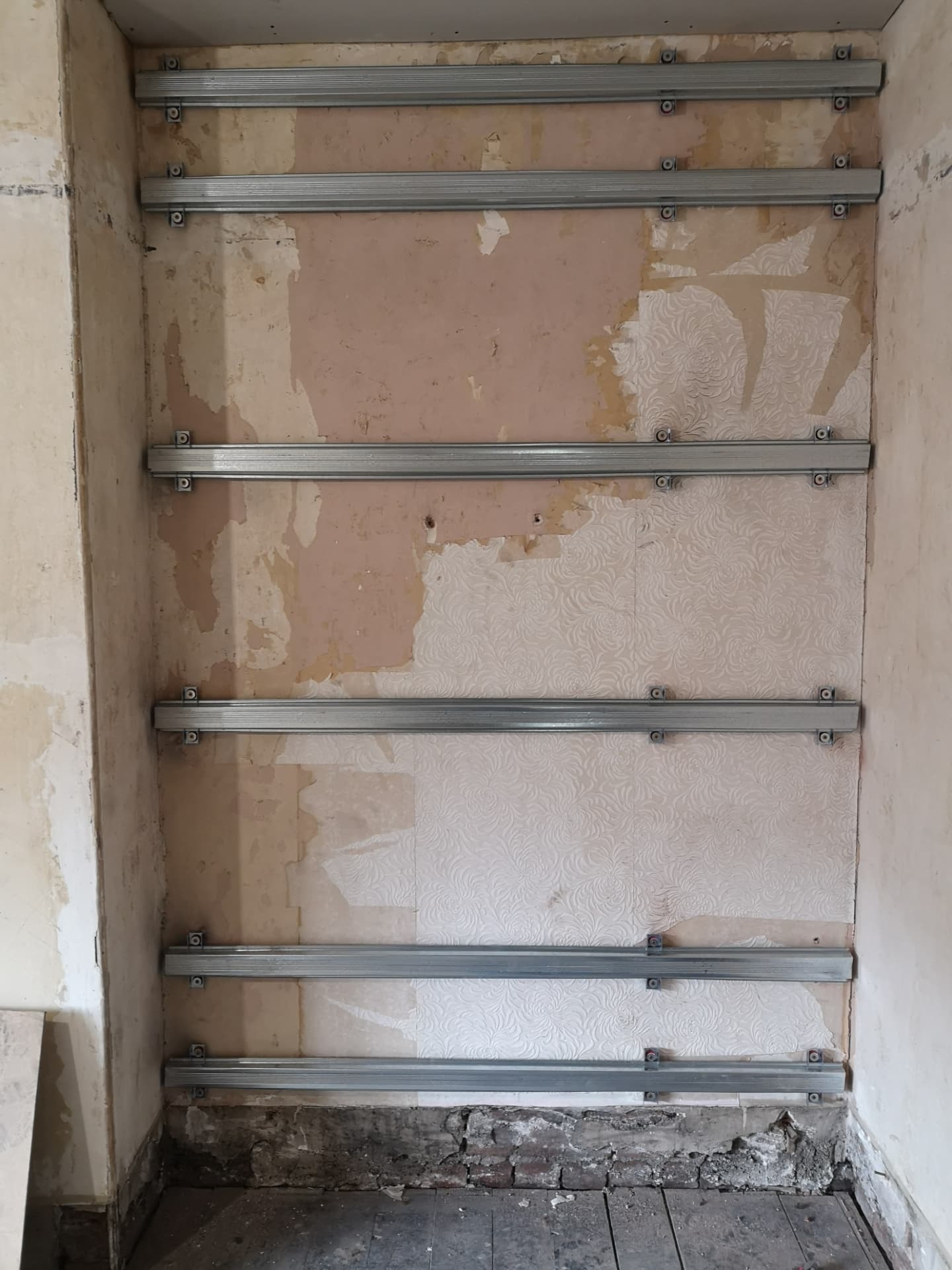 Alcove soundproofing — resilient isolation bars fixed to the original wall